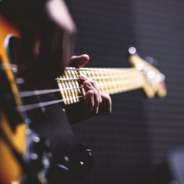 An artistic, motion-blurred photo of a person's hands playing an acoustic guitar