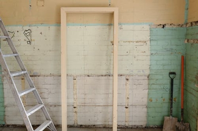 Renovation scene inside a house showing ladders, shovel, and building equipment