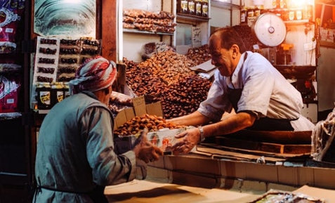 A shopkeeper enthusiastically selling beans