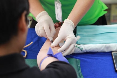 Medical professional administering an injection into the back of a hand