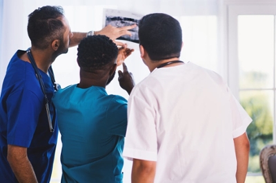 3 healthcare professionals examining a X-ray