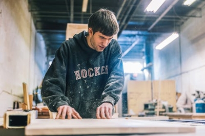A woodworking professional working on a piece of wood